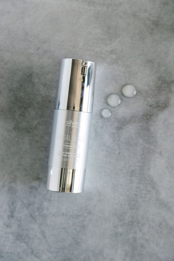 Silver skincare bottle on a gray textured background